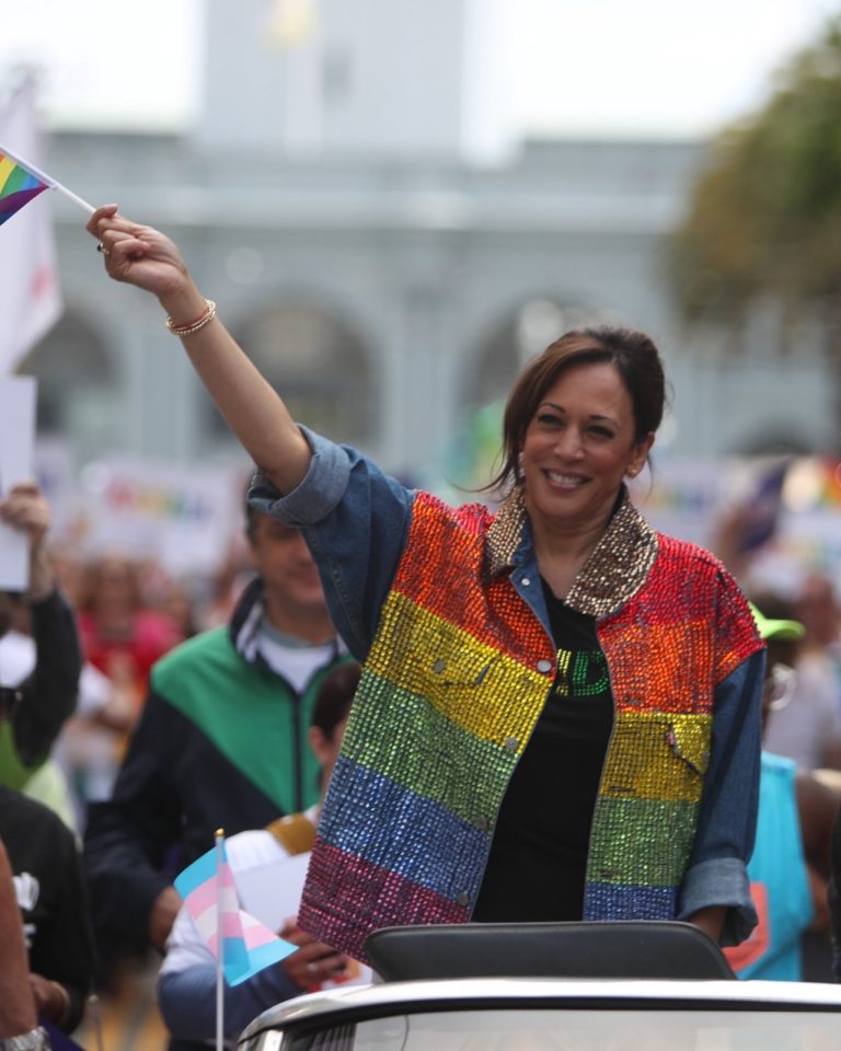 Na snímke viceprezidentka USA a kandidátka Demokratov do prezidentských volieb Kamala Harrisová máva na sprievode LGBTI+ oblečená v dúhových farbách